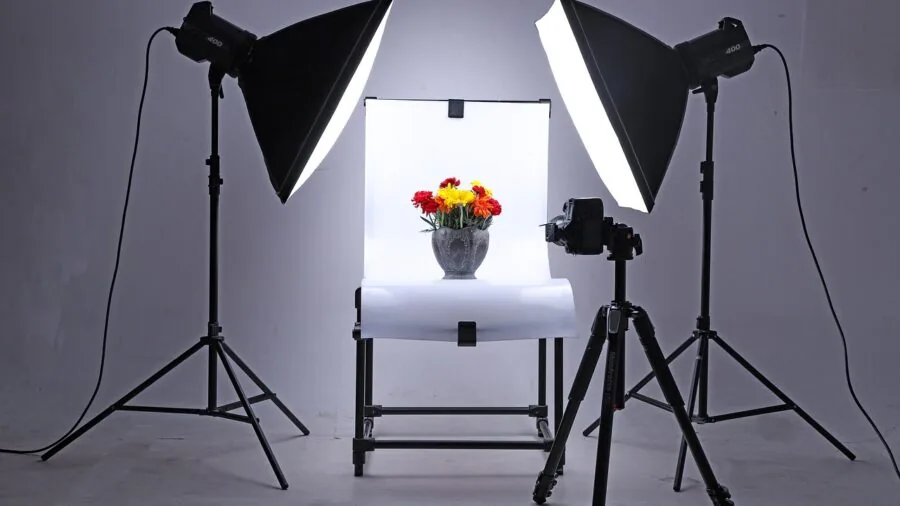 Photographer adjusting softbox lighting in professional studio environment