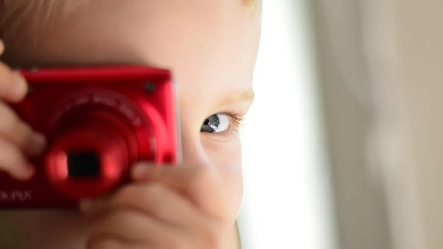 Photographer composing a shot indoors with natural window light, focusing on detail and color clarity