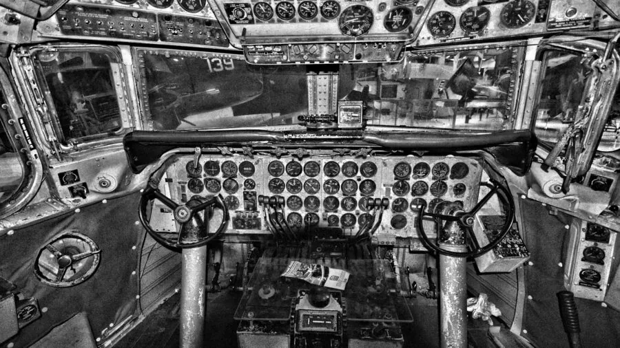 Pilot's hands operating aircraft control stick and throttle in cockpit during flight