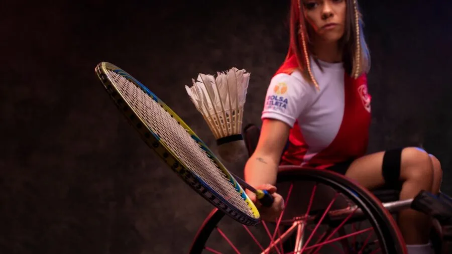 Player examining badminton racket frame before outdoor court match