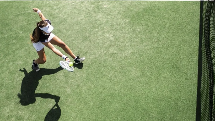 Players competing in outdoor pickleball match on sunny court with natural lighting