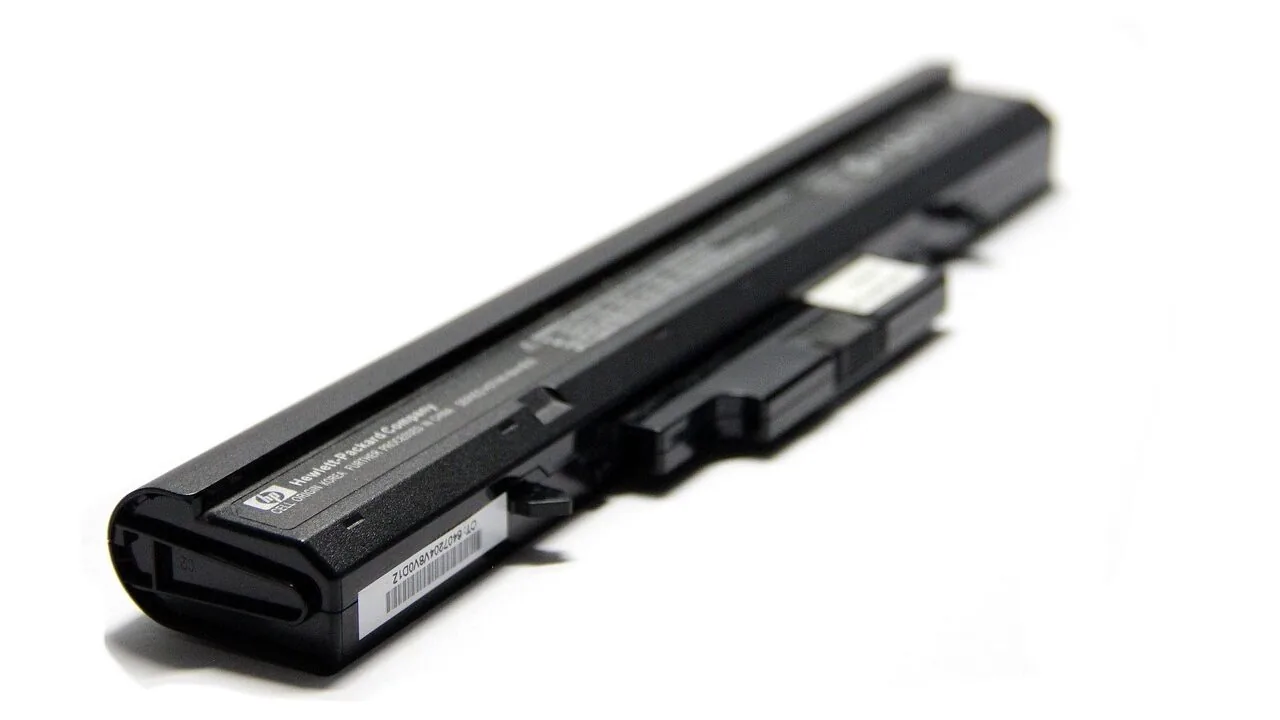Portable car battery charger with cables displayed on vehicle engine background