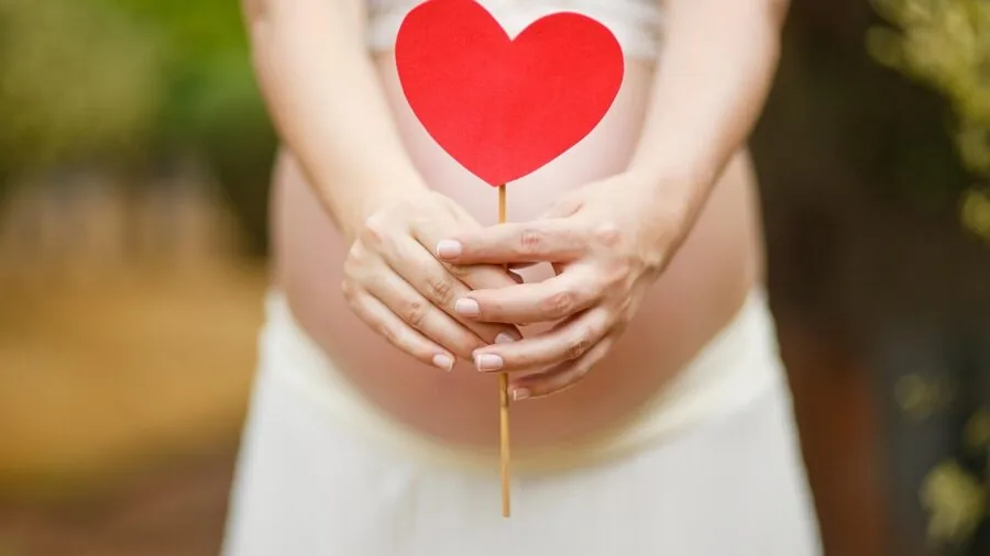 Pregnant woman in stretchy dress demonstrating fabric flexibility and comfort during movement