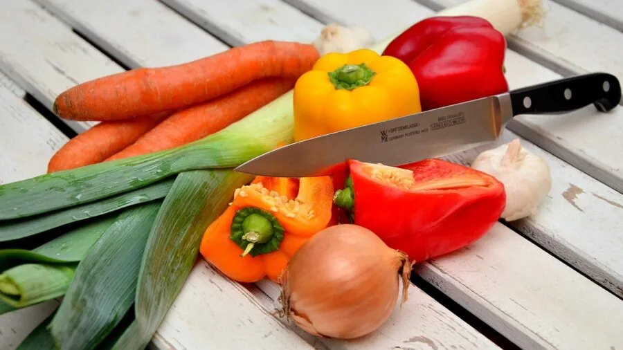 Pregnant woman preparing fresh healthy foods in kitchen for nutritious prenatal diet