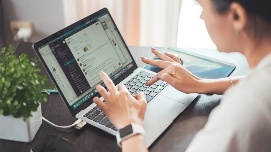 Professional accessing files remotely on laptop from different location, demonstrating cloud backup mobility