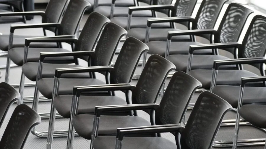 Professional adjusting ergonomic chair armrests at desk for proper posture and comfort