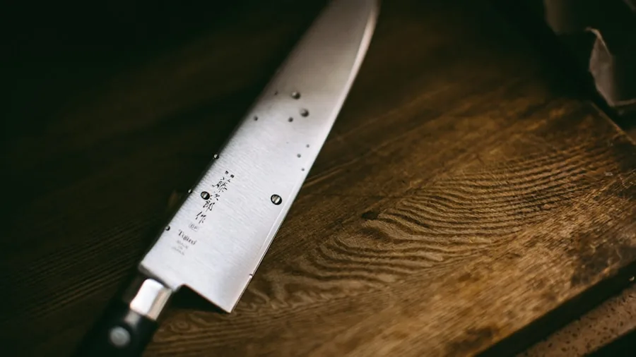 Professional chef carefully sharpening kitchen knife blade with focus on steel and technique