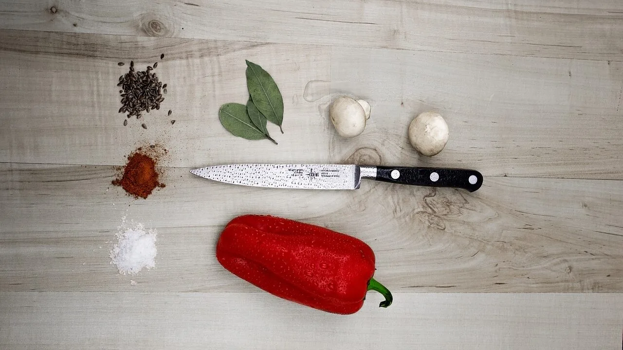 Professional chef knives displayed on wooden cutting board in natural kitchen light
