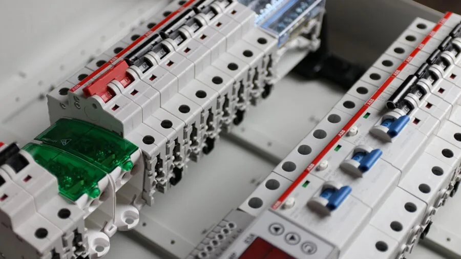 Professional electrician examining electrical panel mechanisms and safety switches in residential home installation