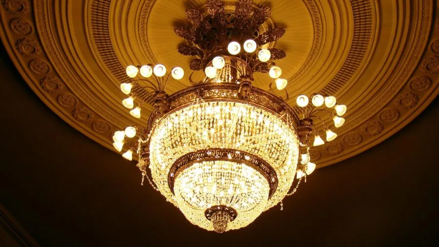 Professional electrician installing a ceiling light fixture in a residential home interior