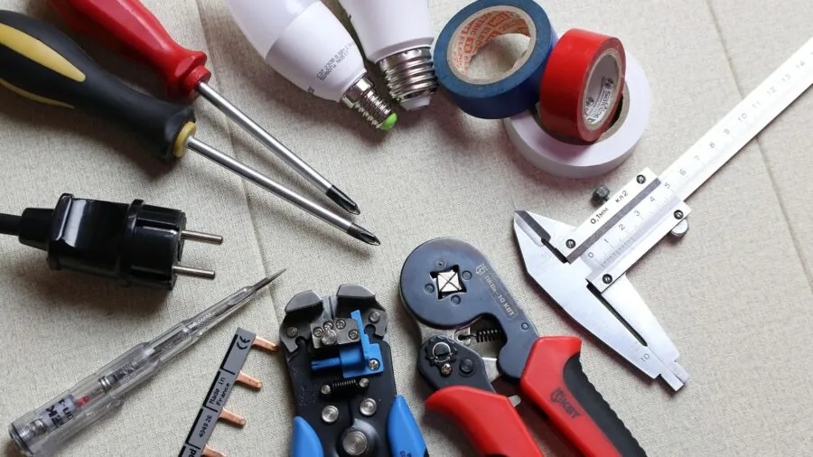 Professional electrician working on ceiling electrical installation and junction box wiring in home interior