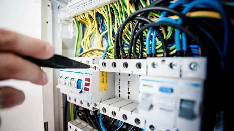 Professional electrician working on hardwired ceiling installation in modern home interior