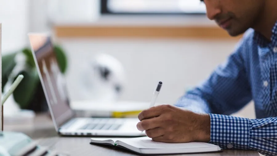 Professional focused on laptop work at desk with concentrated expression