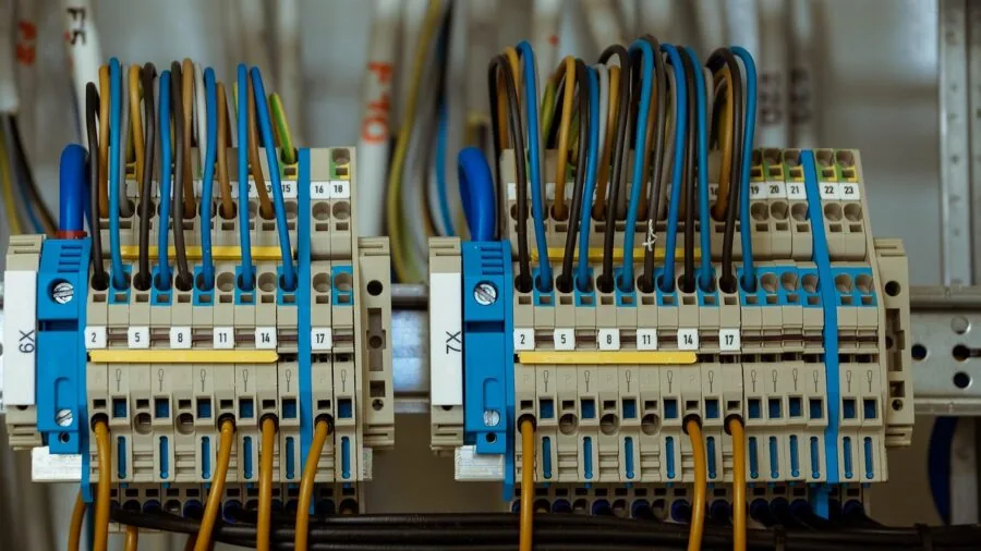 Professional installing electrical wiring and cables in residential home during security system setup