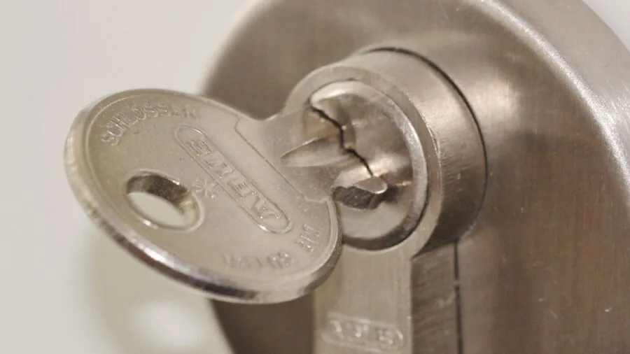 Professional installing reinforced metal security bar on residential door frame