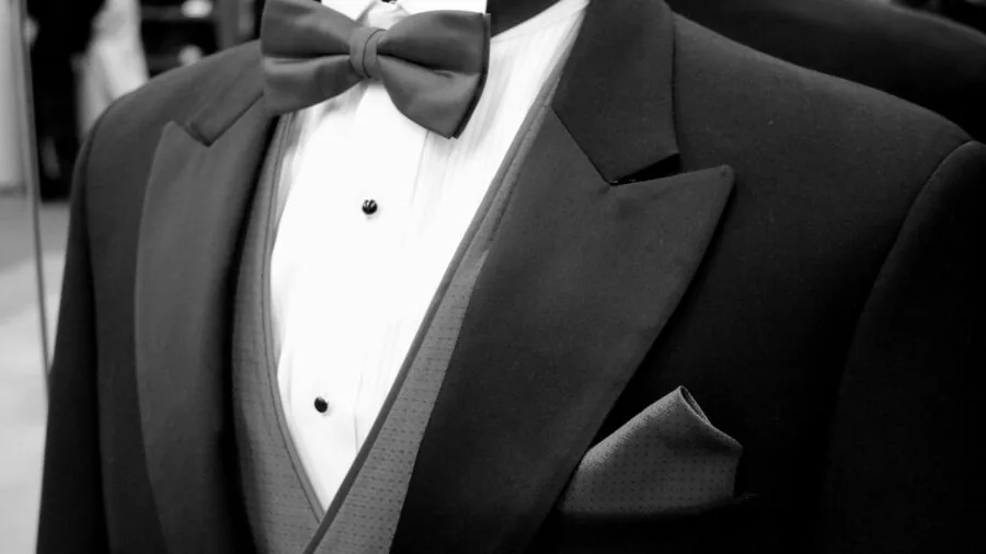 Professional man carefully adjusting and inspecting a necktie for proper knot and construction quality