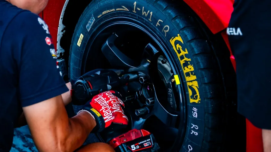 Professional mechanic using power impact wrench on vehicle repair work in garage setting