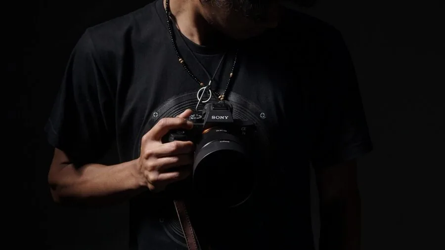 Professional photographer adjusting softbox light during portrait session in studio