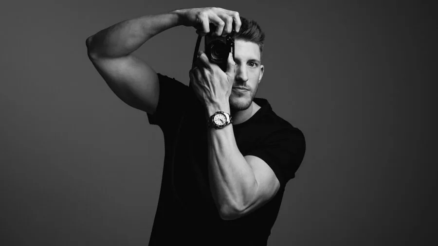 Professional photographer fine-tuning color temperature and lighting setup in modern studio environment