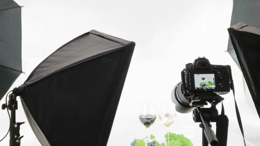 Professional photographer positioning ring light in home studio space with subject