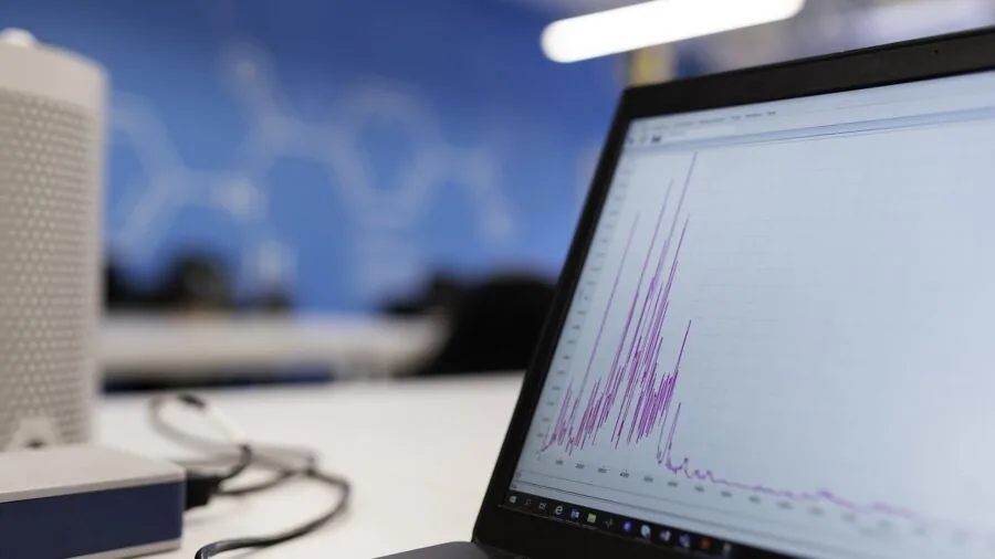 Professional reviewing measurement data on computer screen in modern office workspace