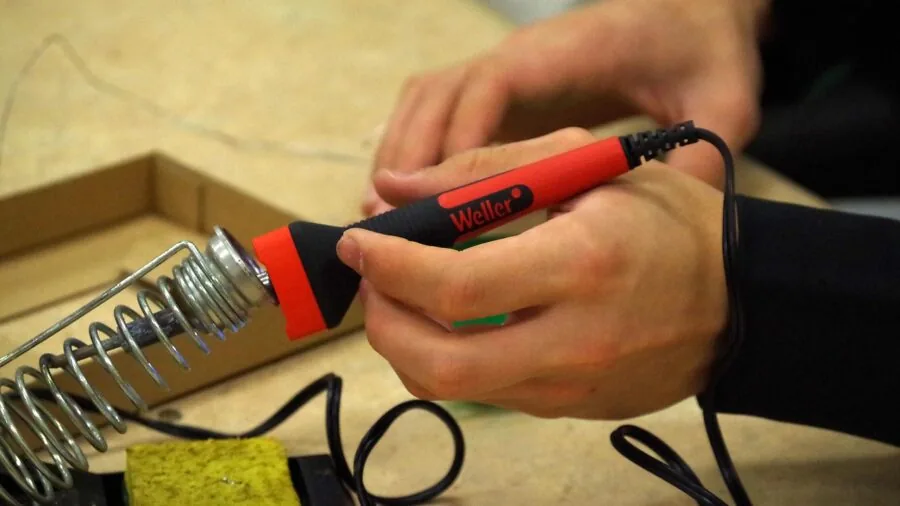 Professional soldering workstation with tools and components for electronic assembly and repair work