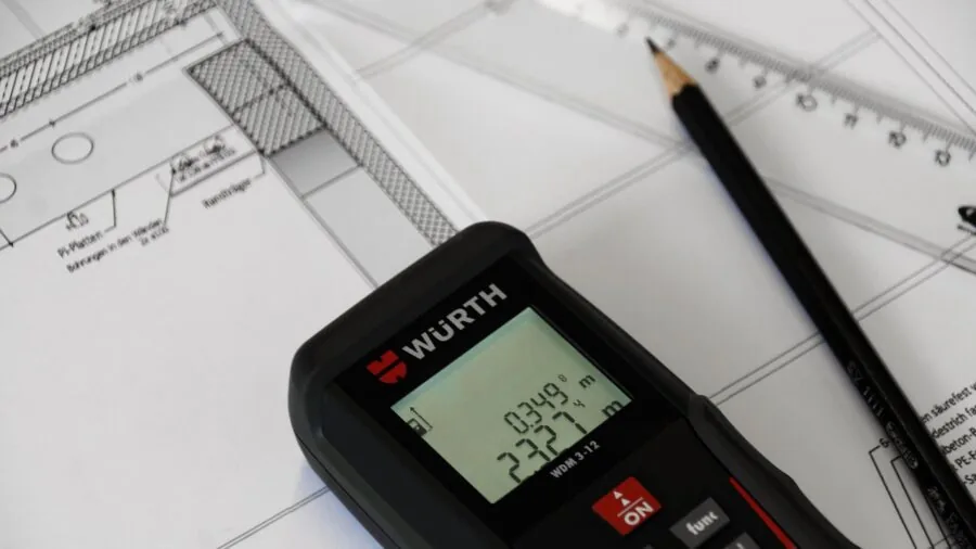 Professional using laser level tool to measure interior wall during home renovation project