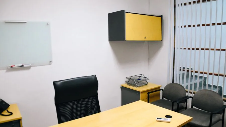 Professional using magnetic elements on whiteboard during team planning session in modern office