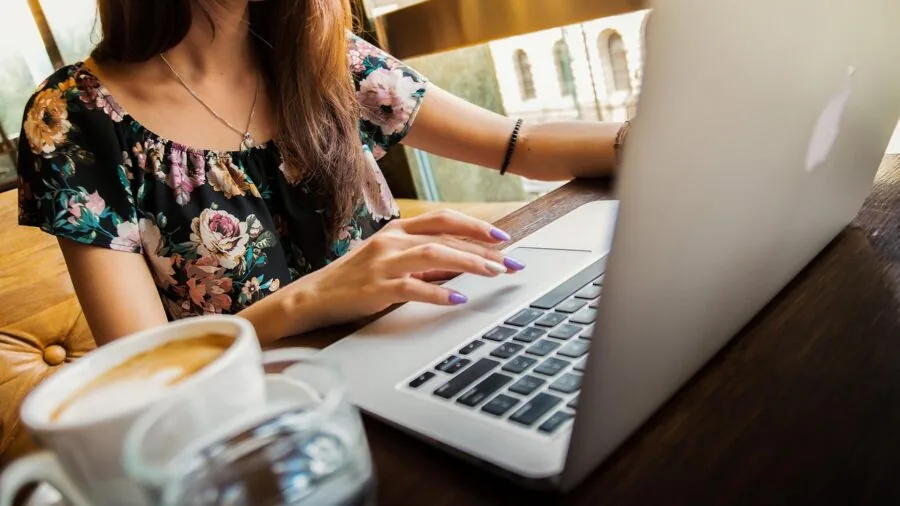 Professional woman with backpack at desk protecting laptop during work