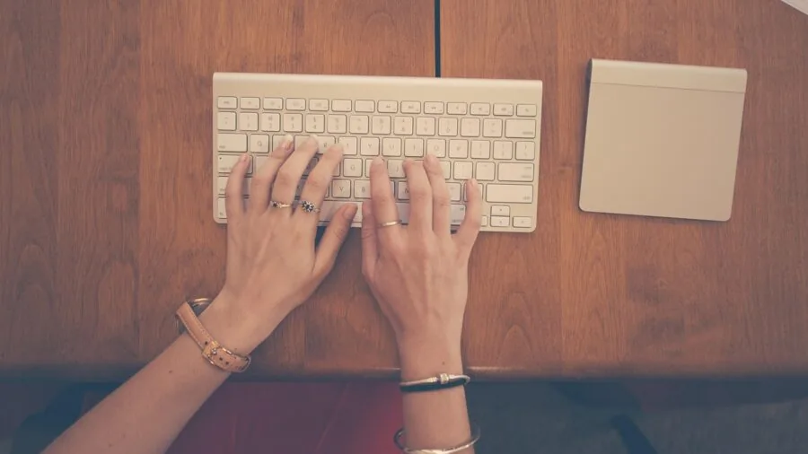 Professional working at desk with keyboard in modern office environment