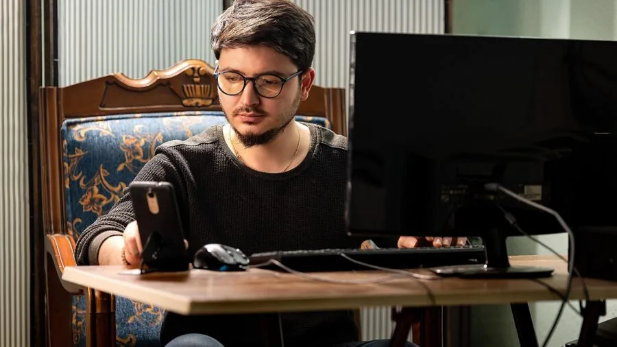 Professional working on laptop at desk with modern tech setup and organized workspace