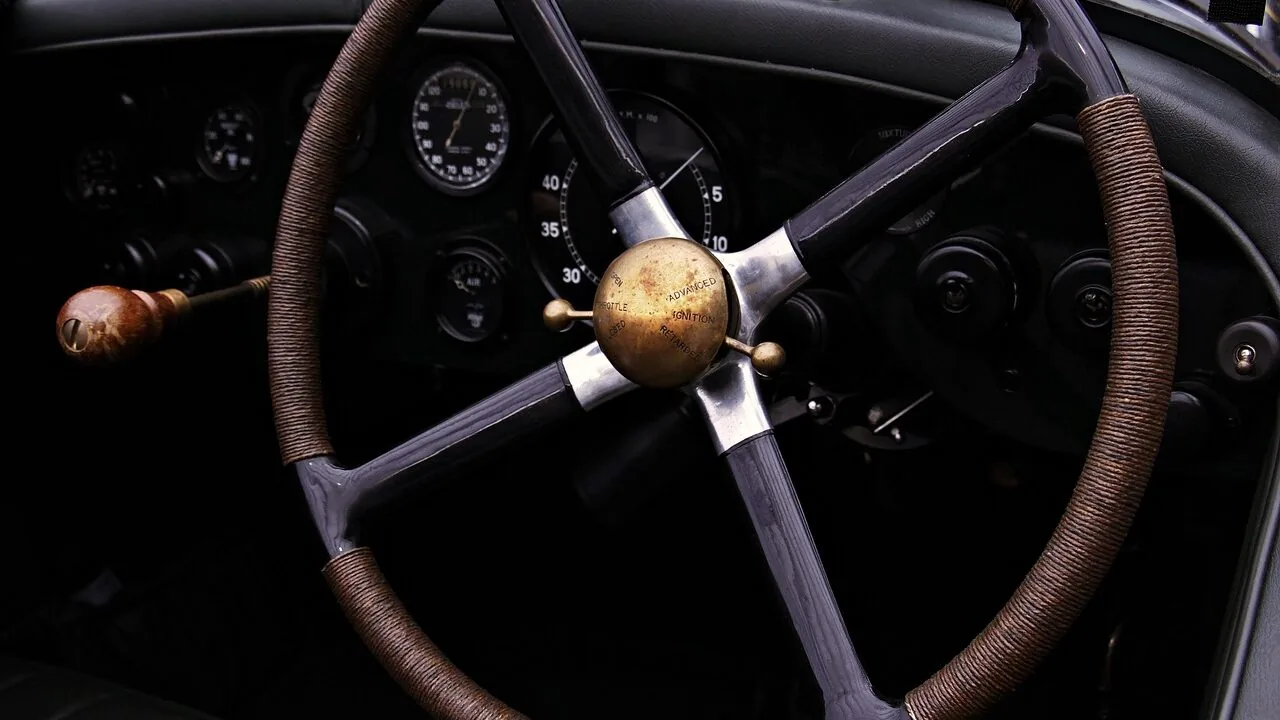 Racing wheel controller mounted on desk with pedals for sim racing
