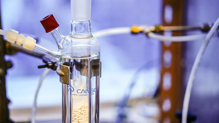 Researcher carefully pouring chemical solution in laboratory setting with protective equipment