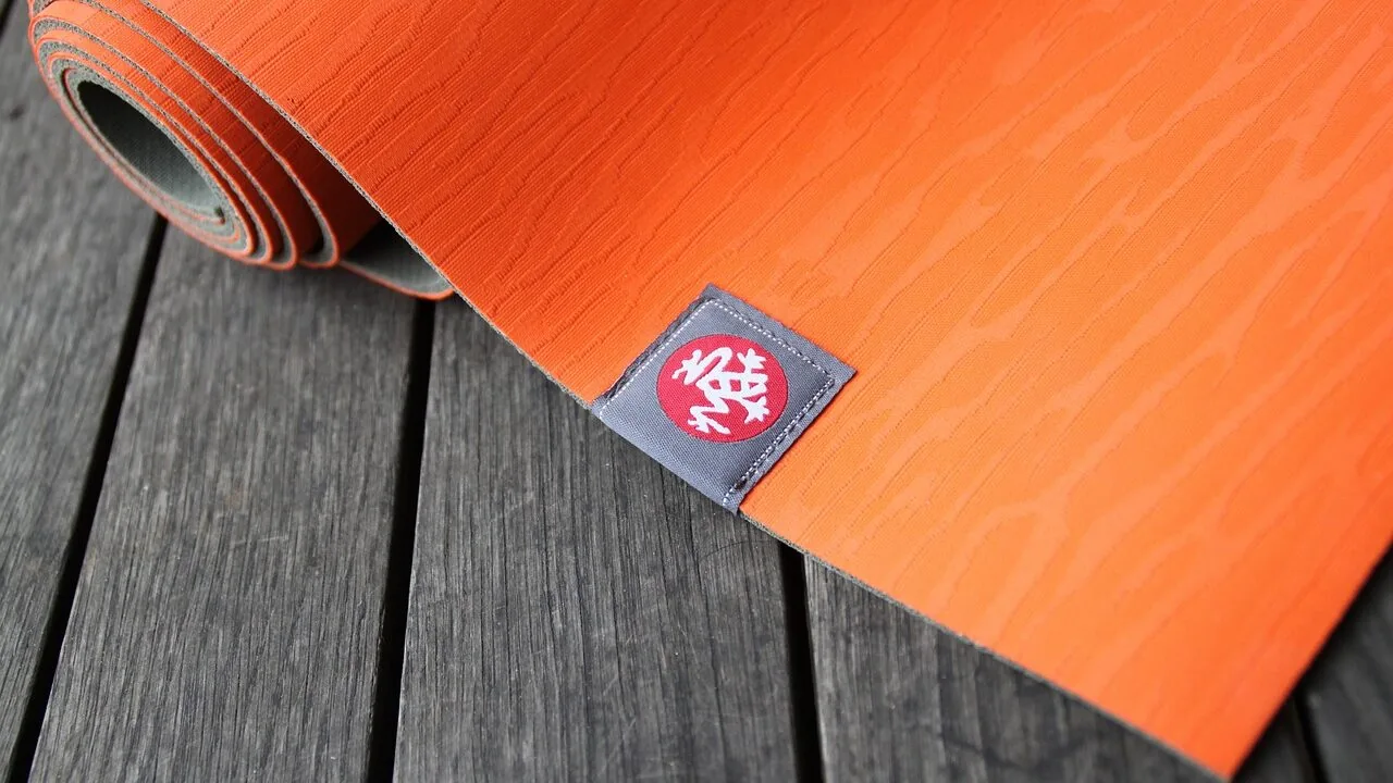 Rolled travel yoga mat in compact carrying form, ready for transport