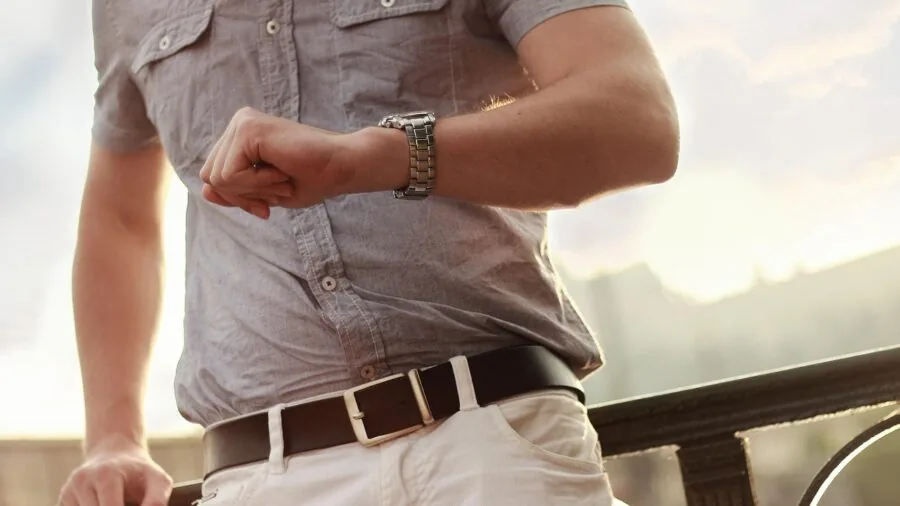 Runner checking sports watch during outdoor exercise on trail