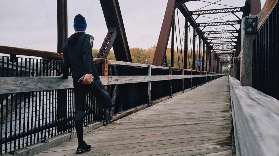 Runner stretching calf muscle after workout on outdoor path