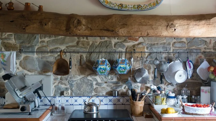 Rustic farmhouse kitchen counter with natural wood bread box and fresh vegetables in morning light