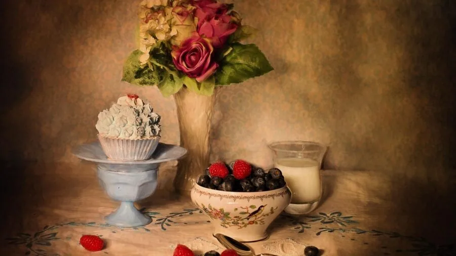 Rustic stoneware dishes and bowls arranged on a natural wooden dining table with warm lighting