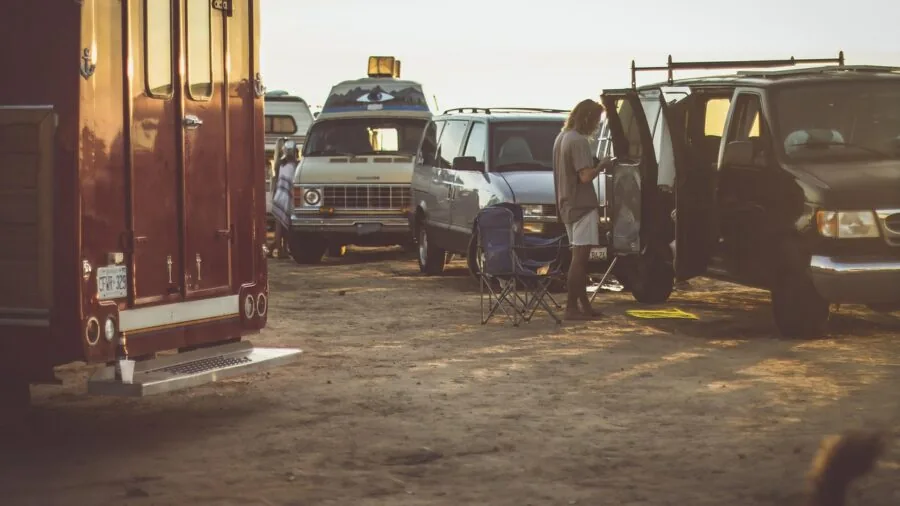 RV parked at campsite with power cord connection during daytime setup