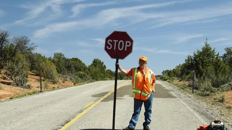 Safety official inspecting road warning equipment during daytime compliance check