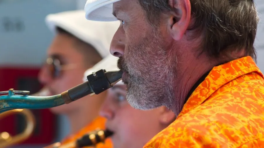 Saxophonist practicing with focused determination in a natural setting, representing skill development and musical progression