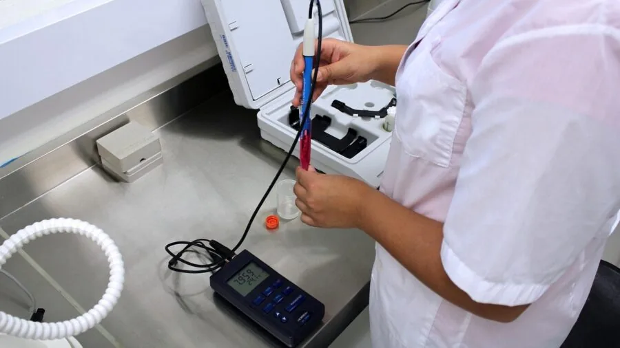 Scientist adjusting temperature settings on equipment in modern lab environment
