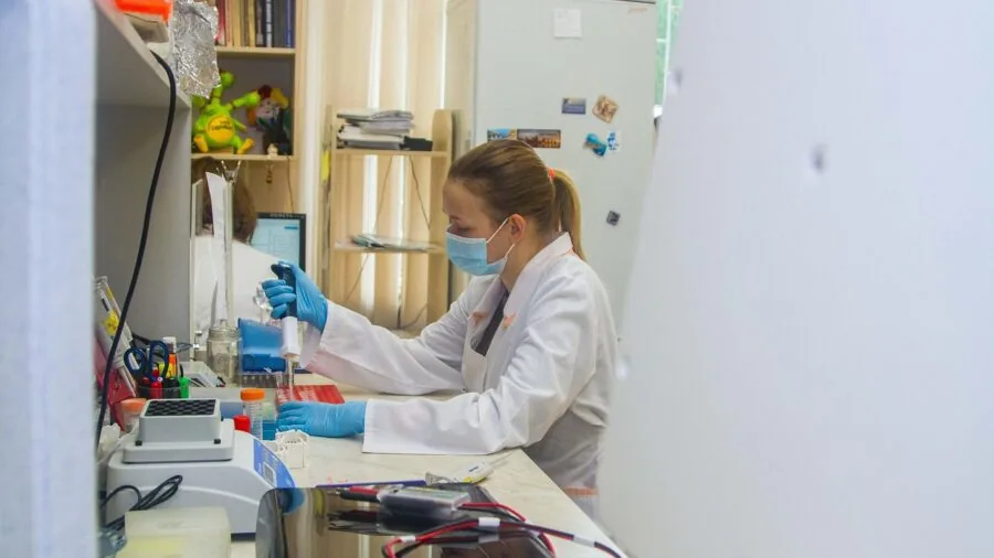Scientist working at laboratory bench with equipment and samples in research setting
