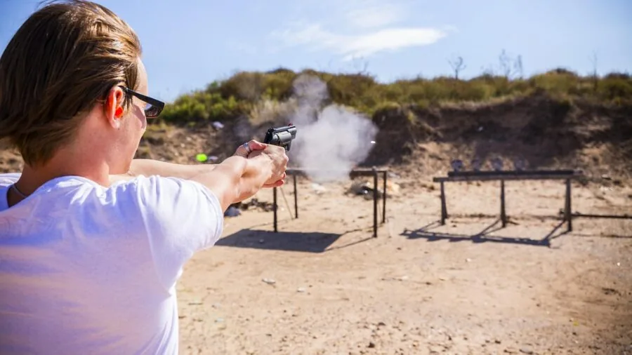 Shooter at outdoor range assessing lighting conditions before practice