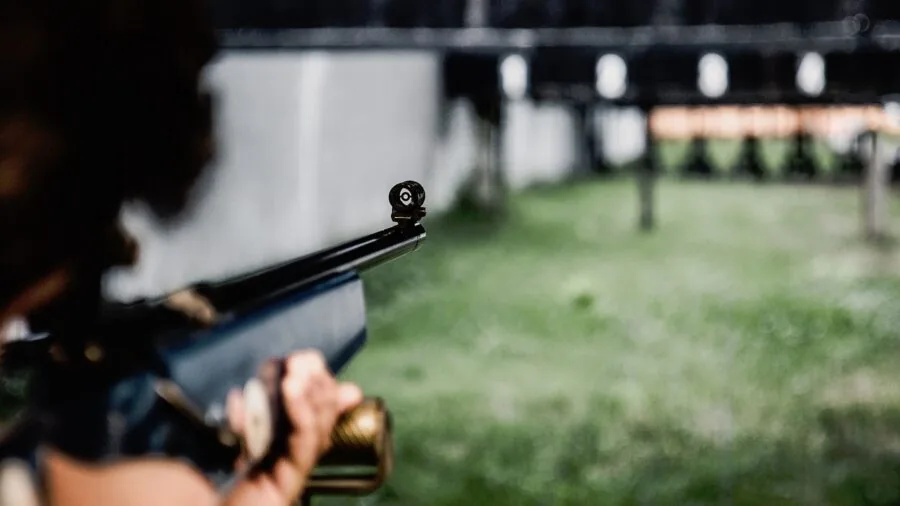 Shooter at outdoor range in bright daylight, demonstrating sight visibility in varying ambient light conditions