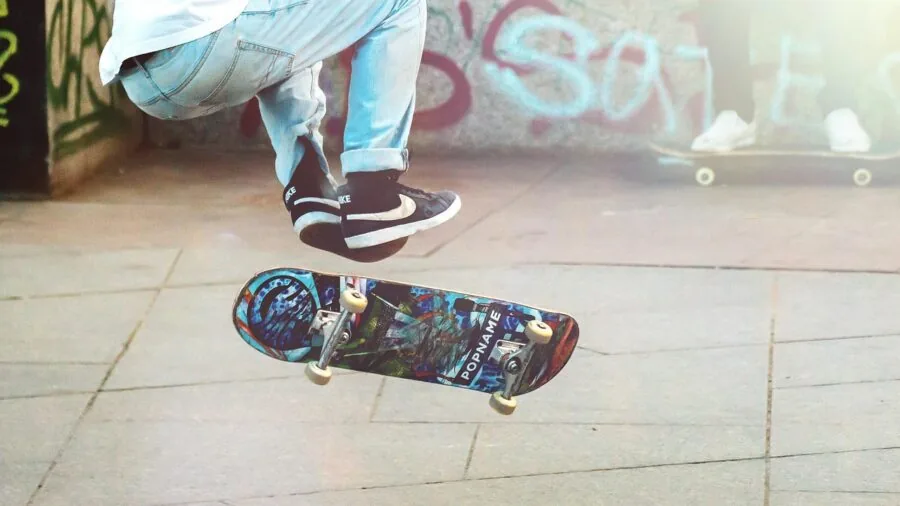 Skateboarder riding longboard on urban street with various deck shapes visible