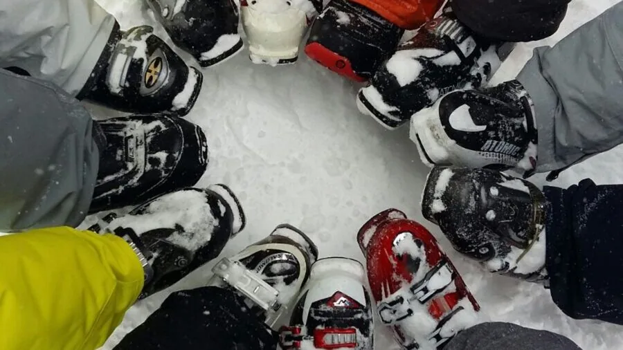 Skier adjusting and fitting ski boots before hitting the slopes