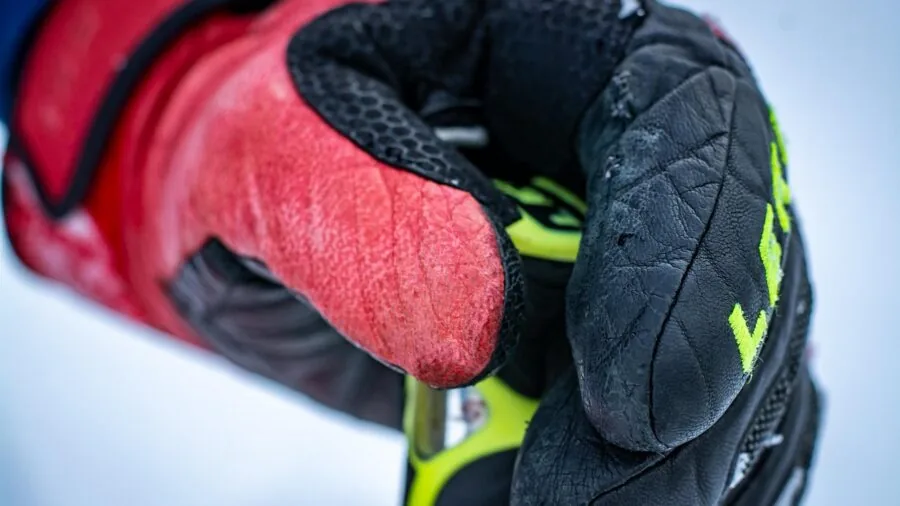 Skier adjusting gauntlet cuff gloves before hitting snowy slopes