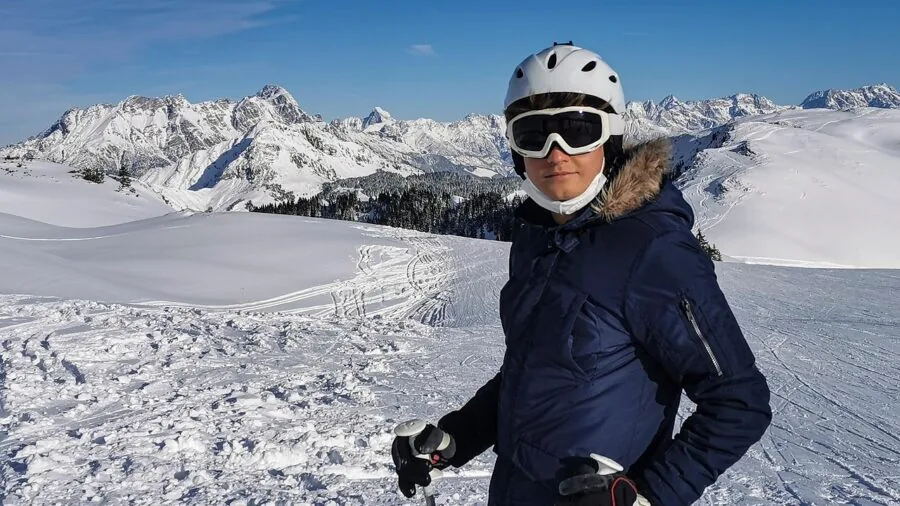 Skier in full gear on snowy slope wearing helmet and goggles during daytime run