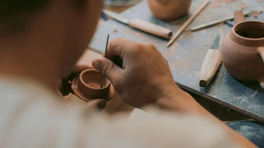 Skilled artisan carefully blending fragrance ingredients in a traditional perfumery workspace